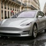 Berline électrique 2024 garée sur un boulevard parisien sous la pluie, carrosserie argentée reflétant l'architecture haussmannienne